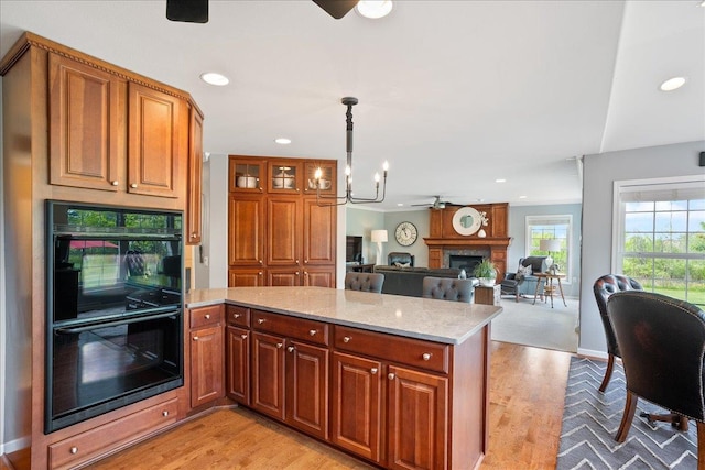 110985 Candlewood Ct, Marshfield, WI 54449 - kitchen with a large fireplace, light wood-style flooring, a peninsula, a ceiling fan, and recessed lighting