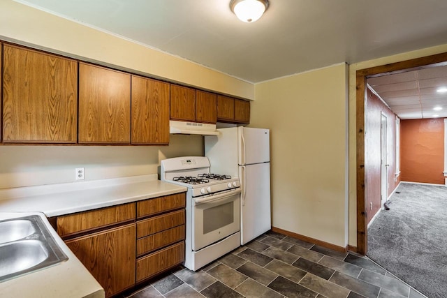 1015 Bluff St, Beloit, WI 53511 - kitchen with white appliances, under cabinet range hood, brown cabinetry, and light countertops