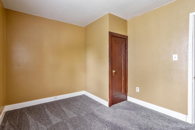 1015 Bluff St, Beloit, WI 53511 - empty room with dark colored carpet and baseboards