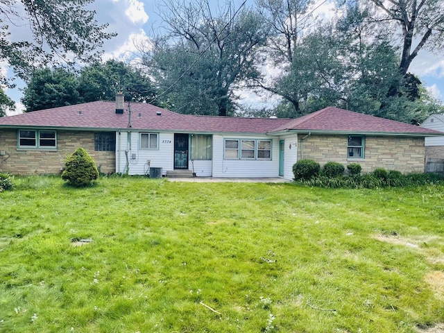 5734 N 80th St, Milwaukee, WI 53218 - back of property with stone siding, a yard, entry steps, and roof with shingles