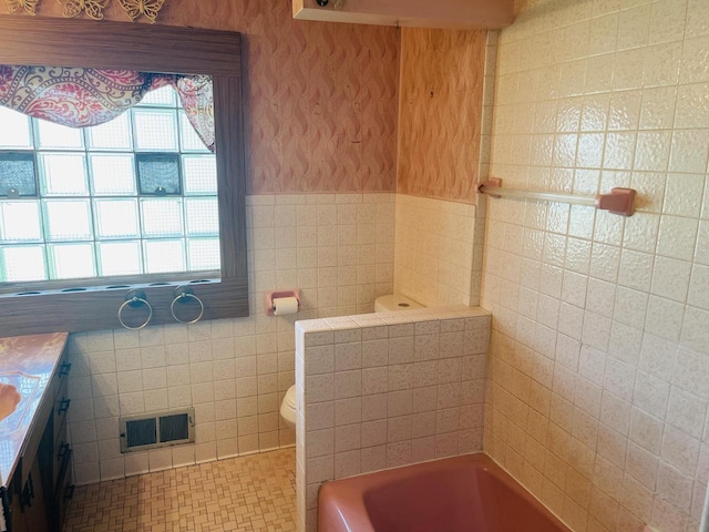 5734 N 80th St, Milwaukee, WI 53218 - bathroom featuring tile walls, a tub, vanity, a wainscoted wall, and wallpapered walls