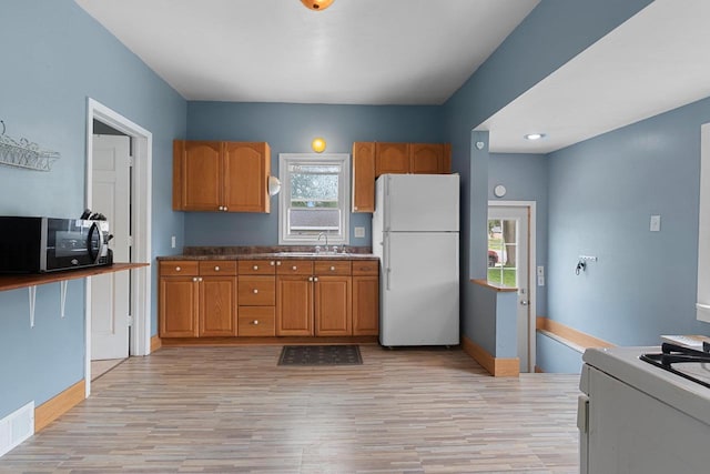 731 S Michigan St, De Pere, WI 54115 - kitchen with white appliances, light wood-style flooring, and brown cabinetry
