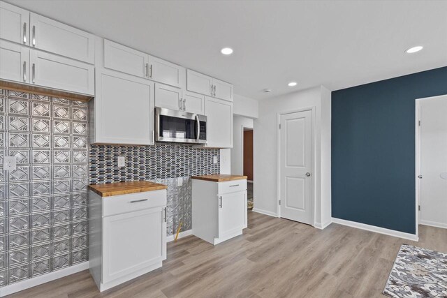 8122 W Potomac Ave, Milwaukee, WI 53218 - kitchen with stainless steel microwave, butcher block countertops, white cabinets, decorative backsplash, and recessed lighting