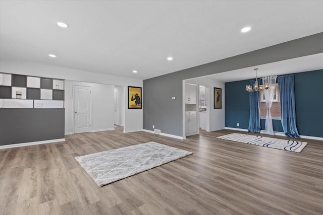 8122 W Potomac Ave, Milwaukee, WI 53218 - unfurnished living room with a chandelier, light wood finished floors, and recessed lighting