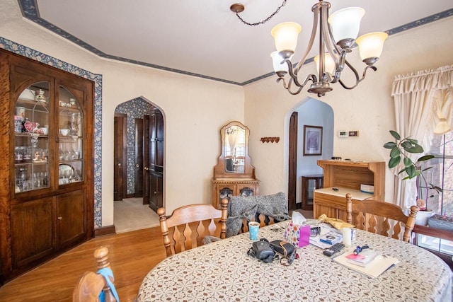 7414 5th Ave, Kenosha, WI 53143 - dining space featuring arched walkways, wood finished floors, a chandelier, and crown molding