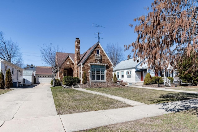 7414 5th Ave, Kenosha, WI 53143 - tudor home with a chimney, a front yard, a garage, and brick siding
