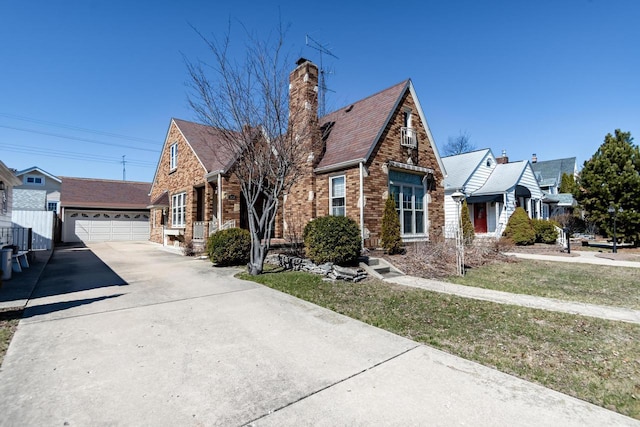7414 5th Ave, Kenosha, WI 53143 - tudor-style house with brick siding, driveway, a chimney, and an outbuilding
