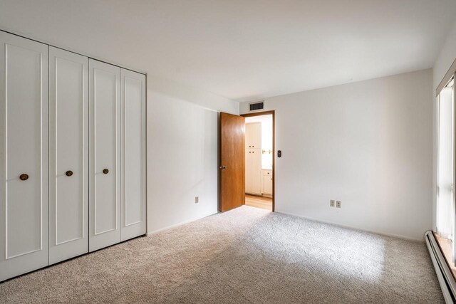 11957 N Appleton Ave Unit 19, Milwaukee, WI 53224 - unfurnished bedroom featuring a baseboard heating unit and light carpet