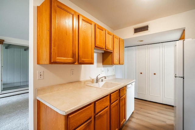 11957 N Appleton Ave Unit 19, Milwaukee, WI 53224 - kitchen featuring white appliances, light countertops, brown cabinetry, and light wood finished floors