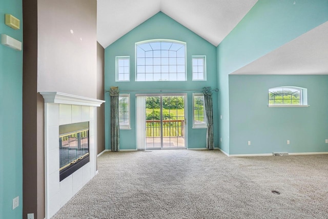 5682 Steeplechase Dr, Waunakee, WI 53597 - unfurnished living room featuring carpet, a tile fireplace, plenty of natural light, and high vaulted ceiling