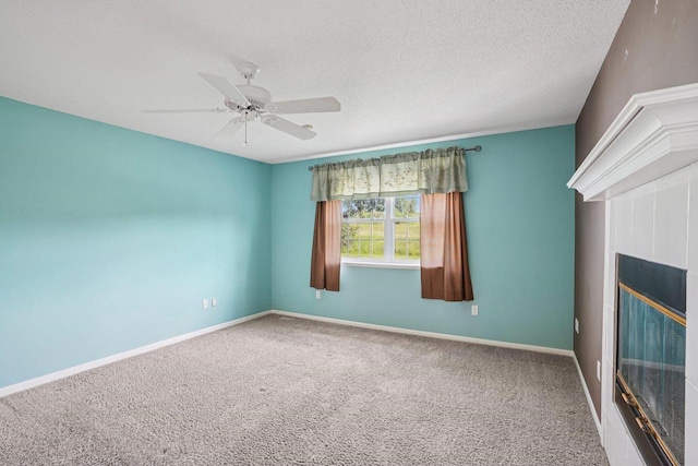 5682 Steeplechase Dr, Waunakee, WI 53597 - carpeted empty room with a ceiling fan, a fireplace, and a textured ceiling