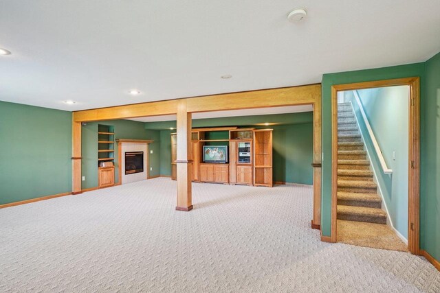 5682 Steeplechase Dr, Waunakee, WI 53597 - finished basement featuring carpet flooring, a glass covered fireplace, recessed lighting, and stairs