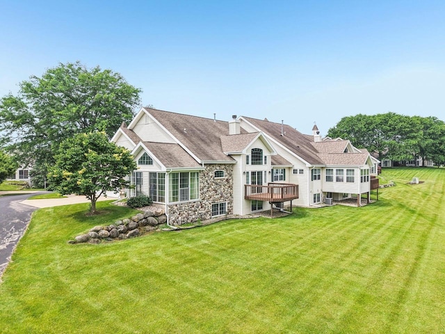 5682 Steeplechase Dr, Waunakee, WI 53597 - back of property with stone siding, a lawn, and a deck