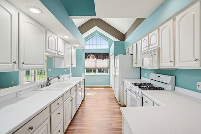 5682 Steeplechase Dr, Waunakee, WI 53597 - kitchen with white appliances, plenty of natural light, lofted ceiling, light wood-type flooring, and white cabinets