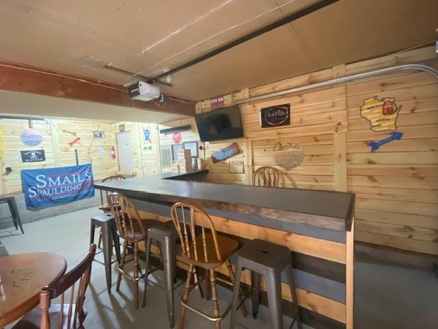 1167 Tee Trl, Nekoosa, WI 54457 - dining space with finished concrete floors, wooden walls, and a bar