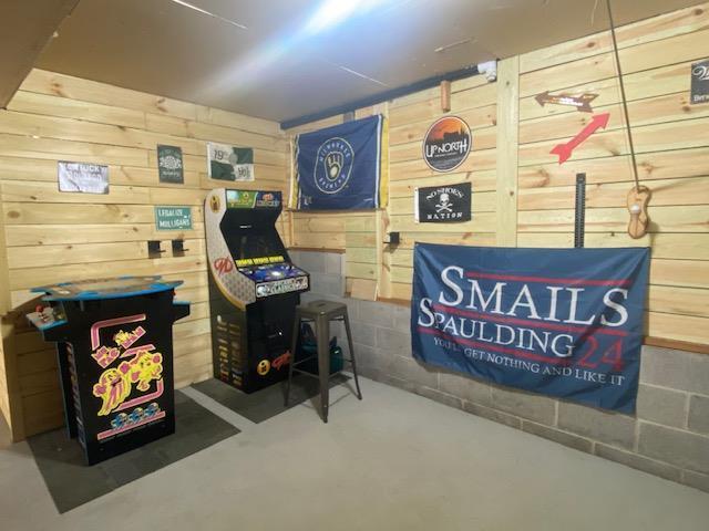 1167 Tee Trl, Nekoosa, WI 54457 - playroom featuring wooden walls and concrete flooring