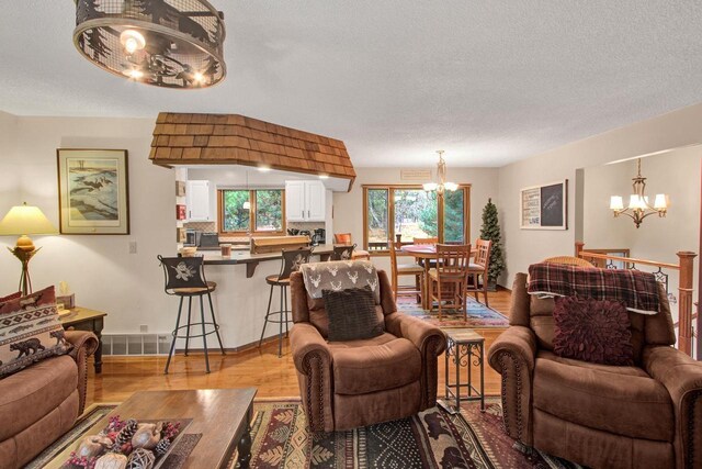 1167 Tee Trl, Nekoosa, WI 54457 - living area with a chandelier, wood finished floors, and a textured ceiling