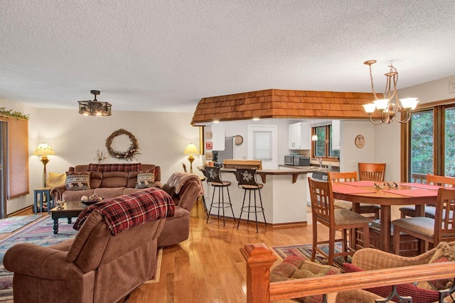 1167 Tee Trl, Nekoosa, WI 54457 - living room featuring a chandelier, a textured ceiling, and light wood-style flooring