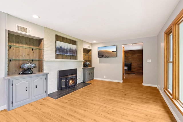 W262S3159 View Dr, Waukesha, WI 53189 - unfurnished living room with wood finished floors, a wood stove, recessed lighting, and healthy amount of natural light
