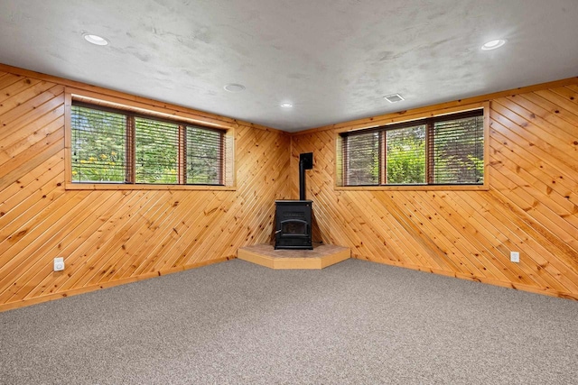 N3520 Range Ct, Freedom, WI 54913 - unfurnished living room with a wood stove, carpet floors, recessed lighting, and wood walls