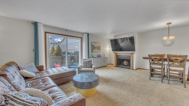 3515 Willow Cir, Sheboygan, WI 53083 - living room featuring carpet, a chandelier, and a warm lit fireplace