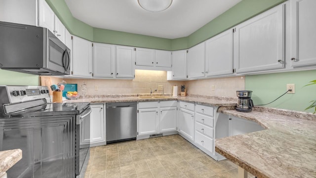 3515 Willow Cir, Sheboygan, WI 53083 - kitchen with appliances with stainless steel finishes, white cabinetry, and light stone counters