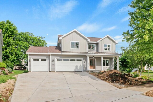 1108 Heritage Ct, Waunakee, WI 53597 - view of front of property with driveway, board and batten siding, covered porch, a garage, and a standing seam roof
