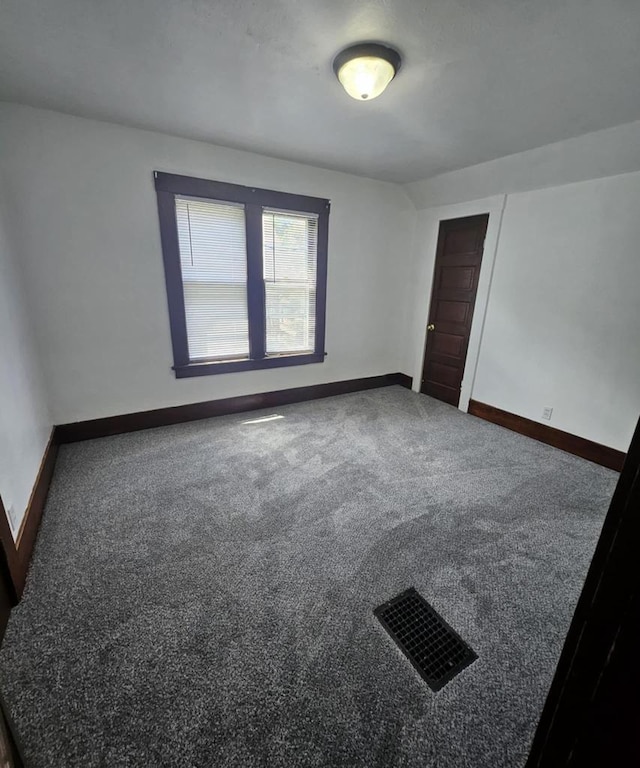 carpeted spare room featuring baseboards
