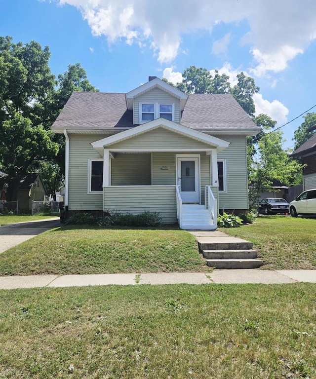 bungalow-style house featuring a front lawn, a porch, and a shingled roof