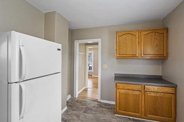 308 Van St, Neenah, WI 54956 - kitchen with freestanding refrigerator, dark countertops, and brown cabinetry