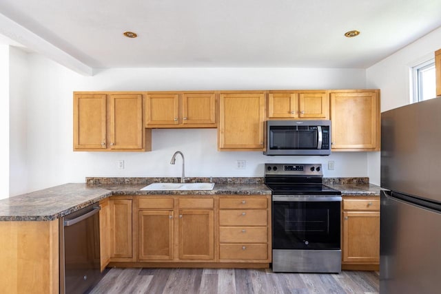 524 W New York Ave, Oshkosh, WI 54901 - kitchen with appliances with stainless steel finishes, dark countertops, light wood-style flooring, and a peninsula