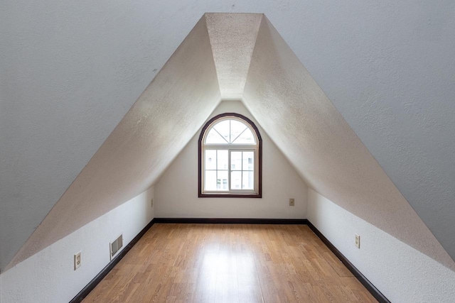 524 W New York Ave, Oshkosh, WI 54901 - bonus room with a textured ceiling, lofted ceiling, and light wood finished floors