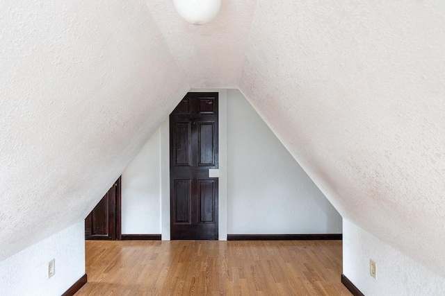 524 W New York Ave, Oshkosh, WI 54901 - bonus room featuring a textured ceiling, vaulted ceiling, and wood finished floors