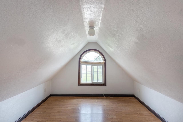 524 W New York Ave, Oshkosh, WI 54901 - bonus room featuring a textured ceiling, wood finished floors, and lofted ceiling