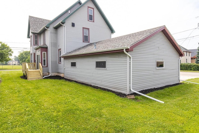 524 W New York Ave, Oshkosh, WI 54901 - rear view of house with a shingled roof and a lawn
