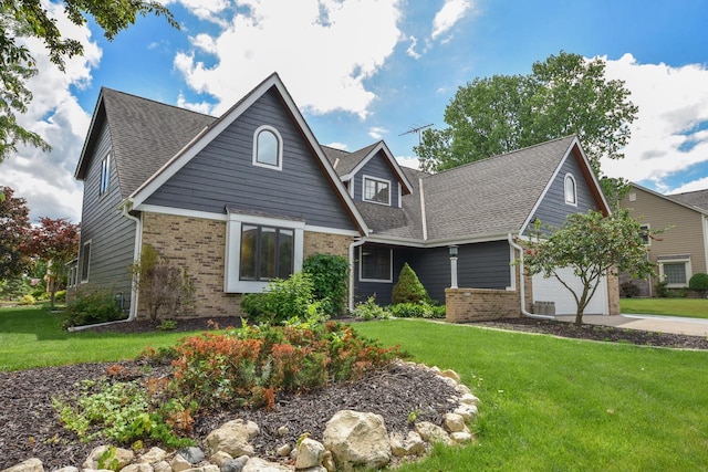 831 Oak Ridge Cir, Hartford, WI 53027 - view of front of house with brick siding, a front lawn, driveway, and a shingled roof