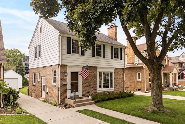 5825 N Bay Ridge Ave, Whitefish Bay, WI 53217 - colonial home with a chimney, an outdoor structure, brick siding, and a front lawn