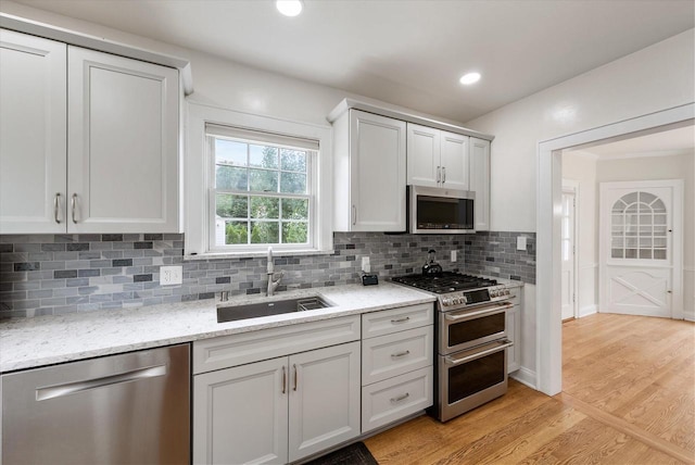 5825 N Bay Ridge Ave, Whitefish Bay, WI 53217 - kitchen with appliances with stainless steel finishes, tasteful backsplash, light wood-style flooring, light stone countertops, and recessed lighting