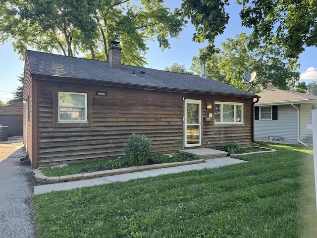 408 N Hine Ave, Waukesha, WI 53188 - view of front of property with a front yard, a chimney, and roof with shingles
