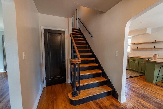 7550 26th Ave, Kenosha, WI 53143 - staircase featuring wood finished floors and arched walkways