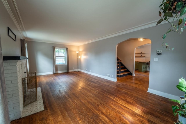7550 26th Ave, Kenosha, WI 53143 - unfurnished living room with arched walkways, wood finished floors, stairs, crown molding, and a fireplace