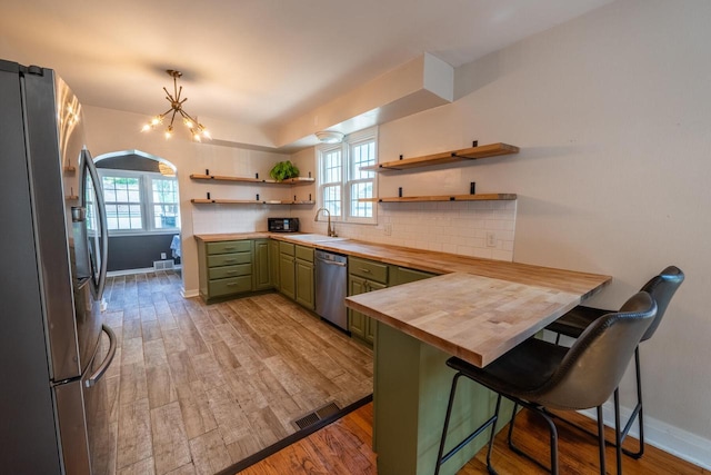 7550 26th Ave, Kenosha, WI 53143 - kitchen with appliances with stainless steel finishes, green cabinetry, wooden counters, open shelves, and a peninsula