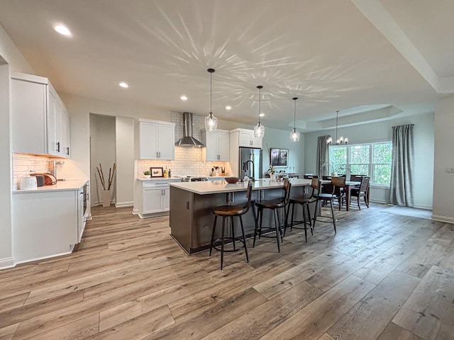 1601 Sauk Trl, Waukesha, WI 53189 - kitchen featuring wall chimney exhaust hood, a breakfast bar area, stainless steel fridge with ice dispenser, light wood finished floors, and recessed lighting