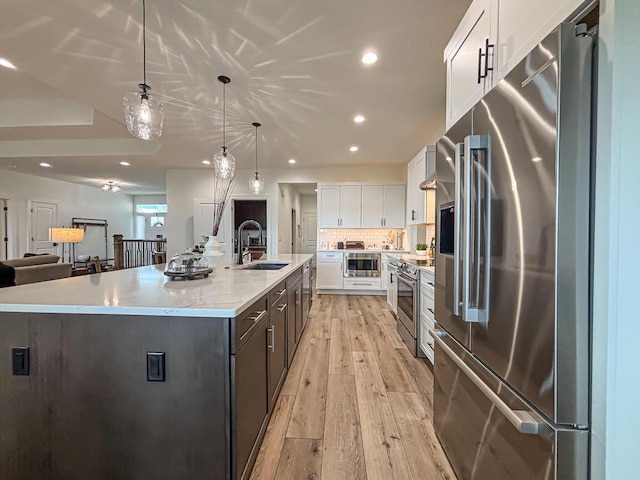 1601 Sauk Trl, Waukesha, WI 53189 - kitchen featuring stainless steel appliances, white cabinetry, a large island with sink, light wood-style flooring, and recessed lighting