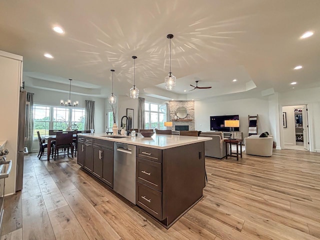 1601 Sauk Trl, Waukesha, WI 53189 - kitchen with appliances with stainless steel finishes, a tray ceiling, a stone fireplace, dark brown cabinets, and recessed lighting