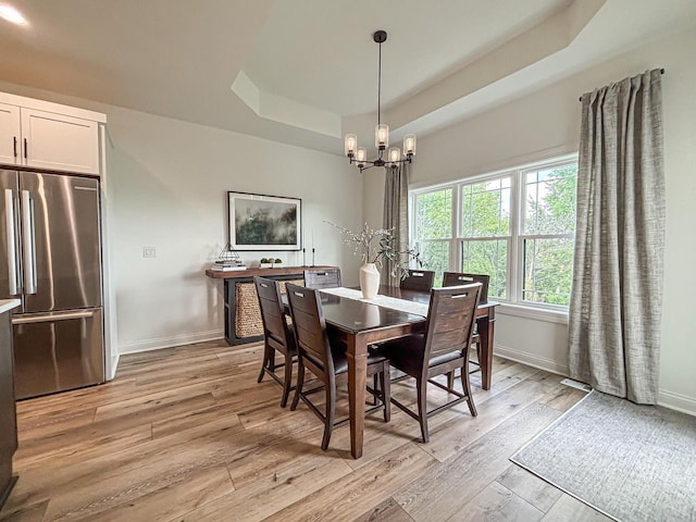 1601 Sauk Trl, Waukesha, WI 53189 - dining space featuring a raised ceiling, a chandelier, and light wood-style floors