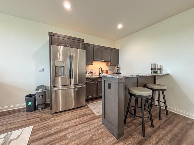 1601 Sauk Trl, Waukesha, WI 53189 - kitchen with stainless steel fridge with ice dispenser, a breakfast bar, dark wood finished floors, dark brown cabinets, and recessed lighting