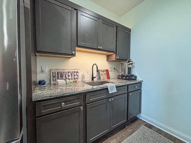 1601 Sauk Trl, Waukesha, WI 53189 - kitchen featuring light stone counters, freestanding refrigerator, and dark wood-type flooring