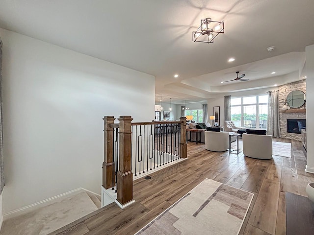 1601 Sauk Trl, Waukesha, WI 53189 - hallway with light wood-style flooring, a tray ceiling, recessed lighting, and an upstairs landing