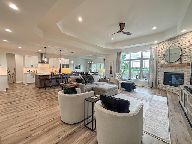 1601 Sauk Trl, Waukesha, WI 53189 - living area featuring a raised ceiling, light wood finished floors, ceiling fan, recessed lighting, and a fireplace